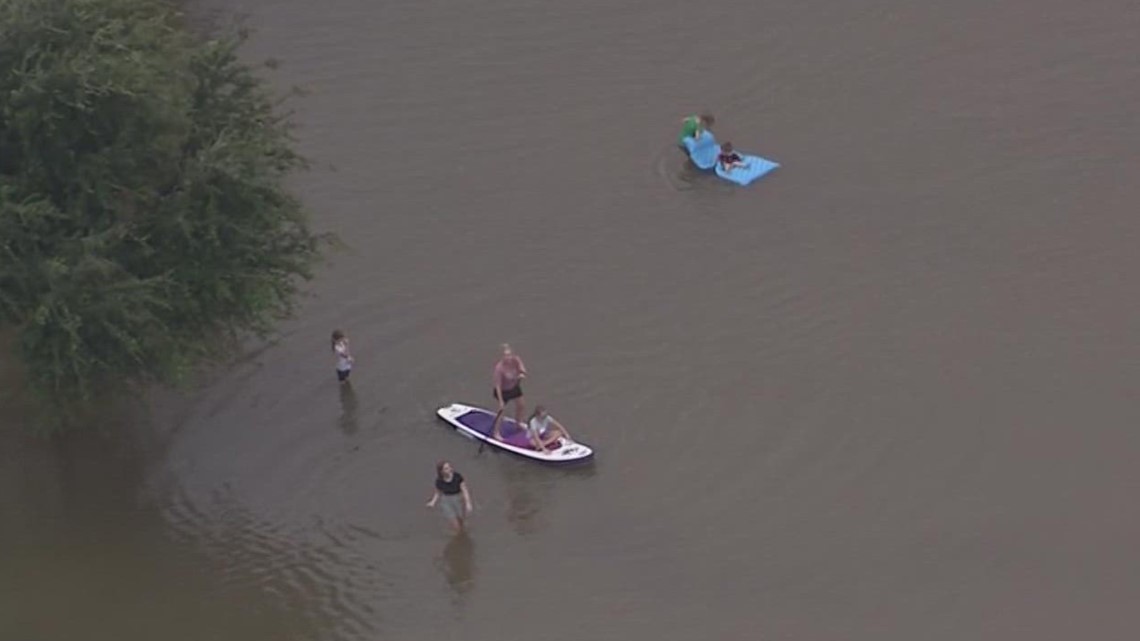 Anak-anak, kayak, dan anjing keluar untuk bermain di daerah banjir Gilbert