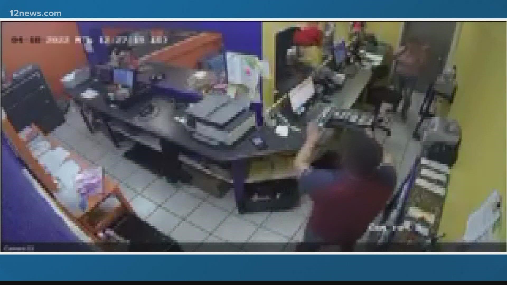Man with a gun seen threatening employees, jumping the counter and robbing a business in West Phoenix.