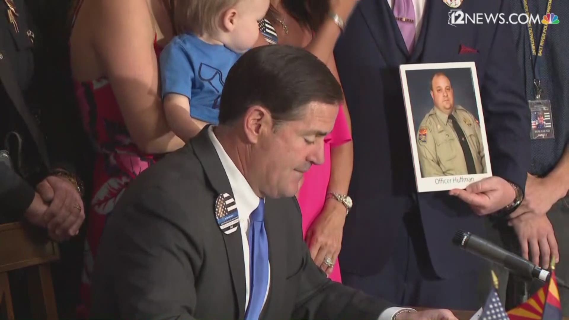 The family of Salt River tribal officer Clayton Townsend who was killed when he was struck by a distracted driver stood behind Arizona Gov. Doug Ducey as he signed HB 2318 into law.