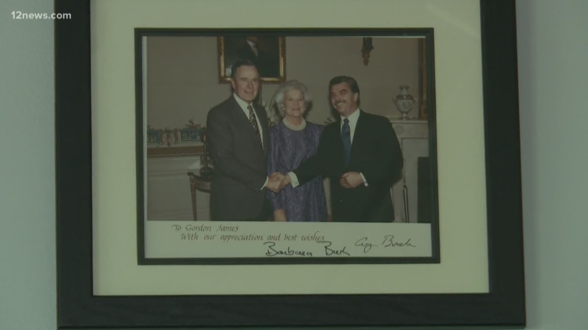 Gordon James worked closely with President George H.W. Bush for more than 40 years. His walls are framed with pictures of their work and adventures together.