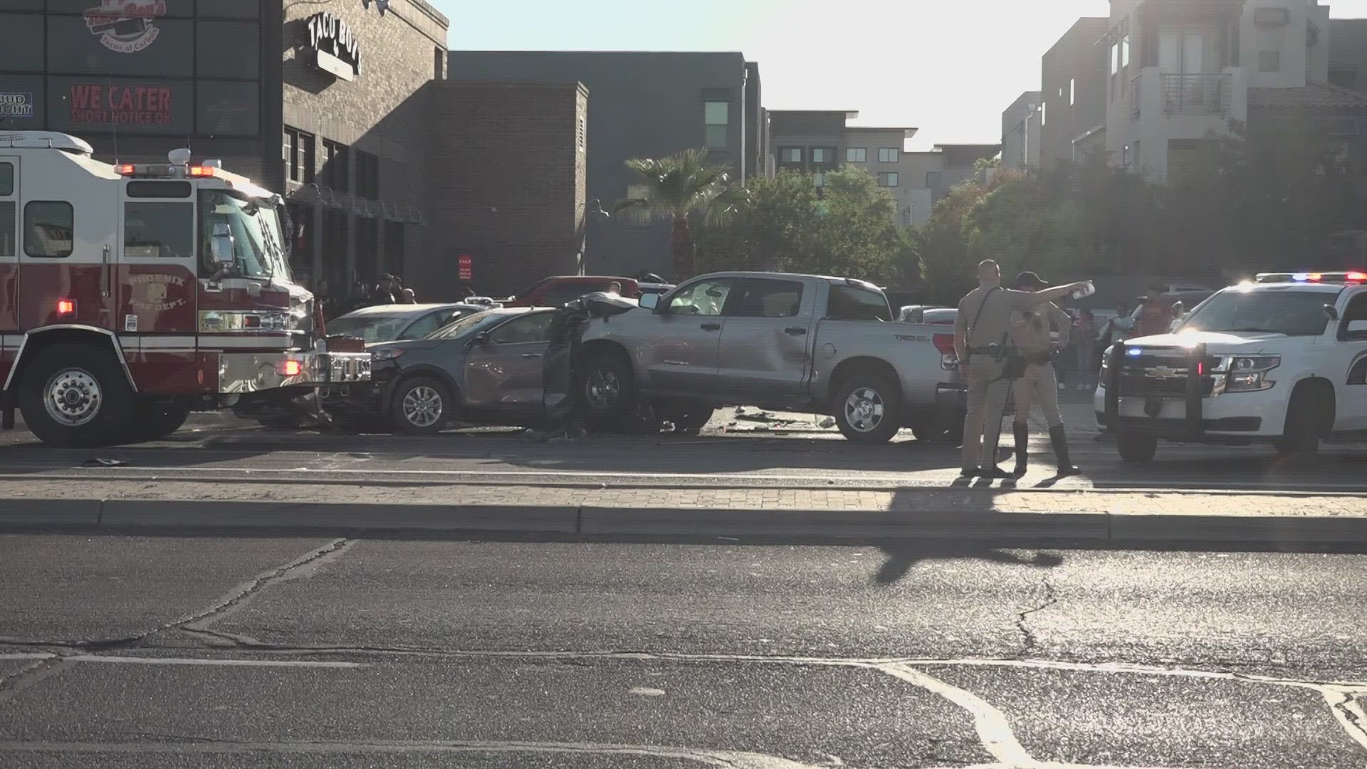 A suspect is in custody after stealing multiple vehicles at gunpoint, hitting a woman with a car, and crashing into a home in Phoenix, police said.