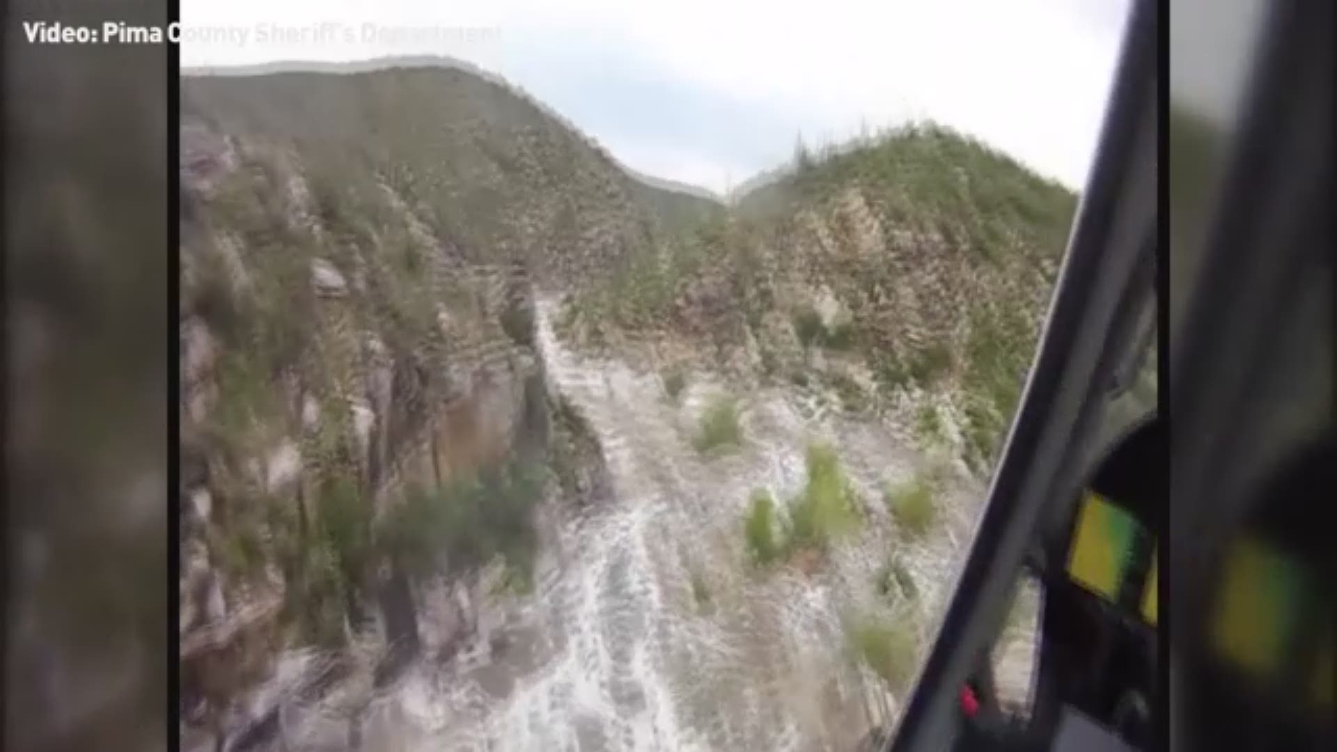 Video from the Pima County Sheriff's Department shows a father and child being airlifted from rushing waters after a flash flood stranded 17 hikers in the Tanque Verde Falls area of Redington Pass.