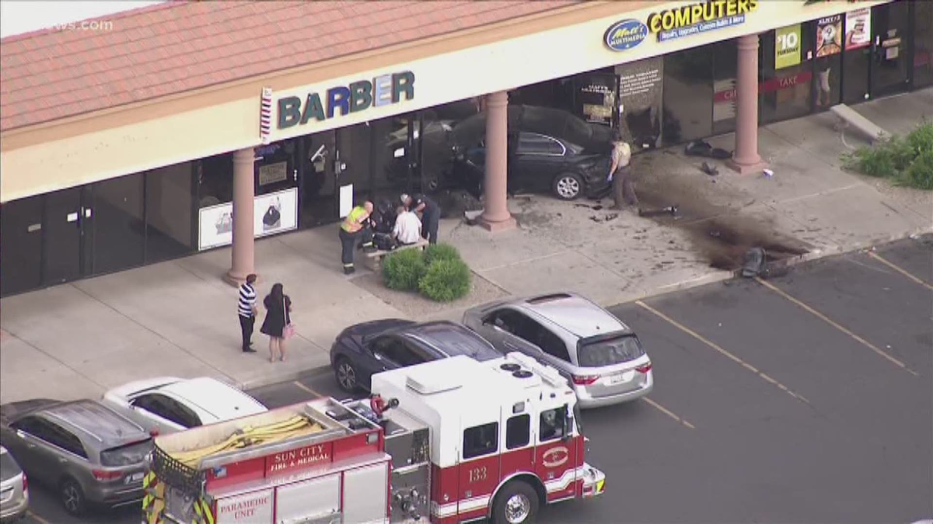 A black sedan went through the front of a barber shop and a computer store near 107th Ave. and Grand Ave. in Sun City. It appears the sedan was involved in a crash with another sedan before crashing into the building.