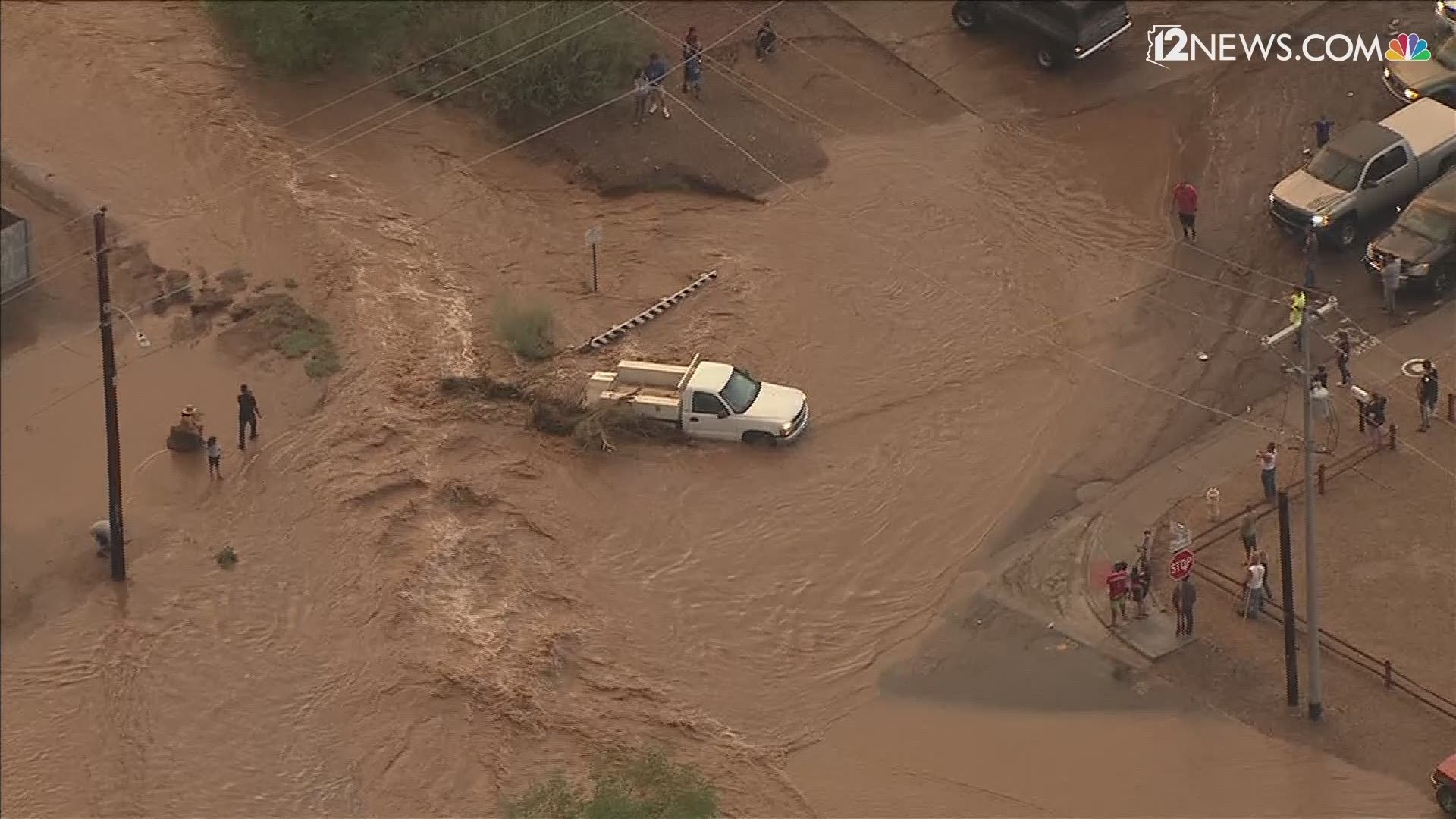 Two trucks were hauled out of flooded washes after the drivers were rescued near 11th Street and Dunlap Avenue.