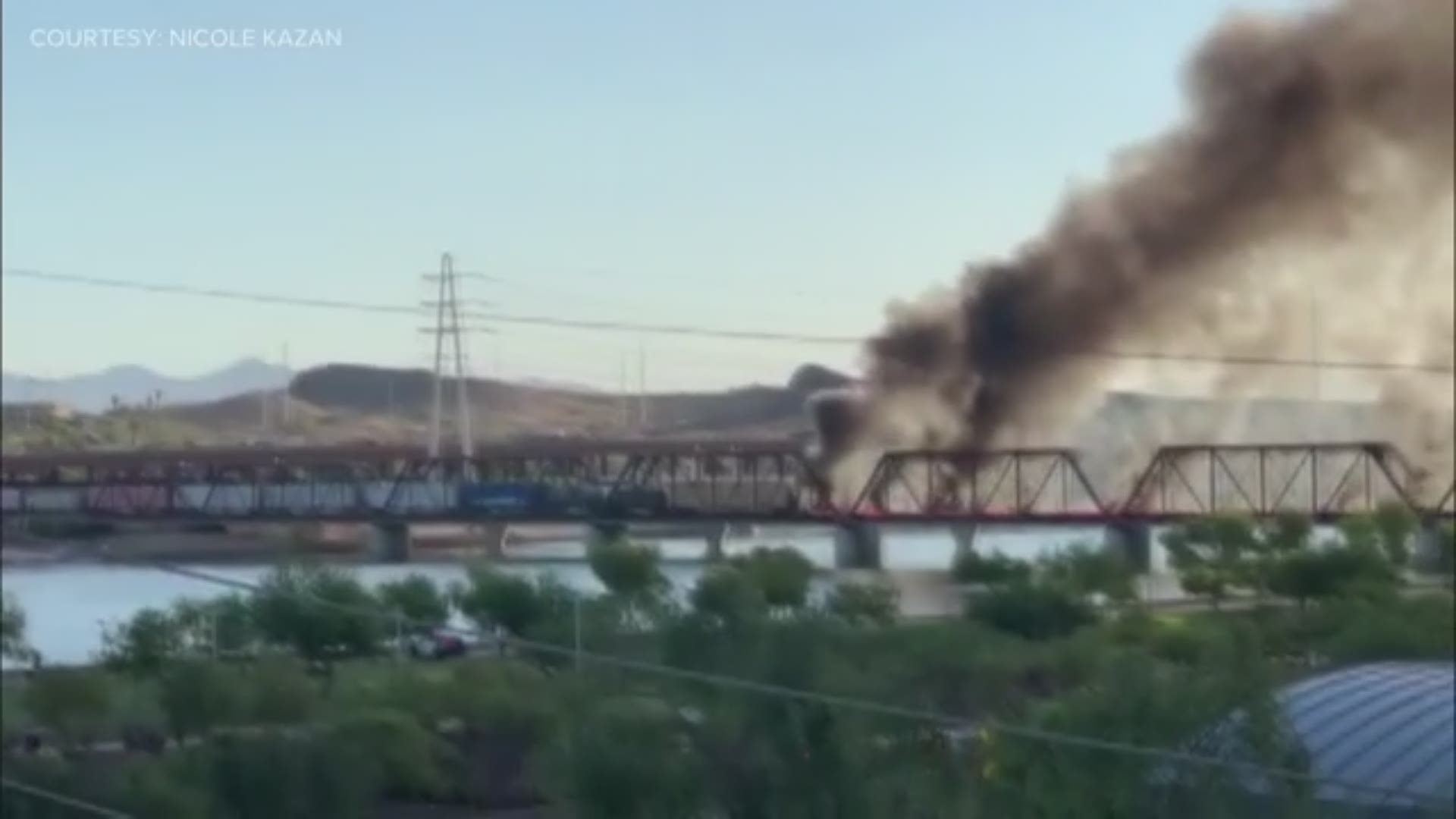 Video from Nicole Kazan shows smoke pouring from the train derailment on a Tempe Town Lake bridge. The train was on fire from the incident.