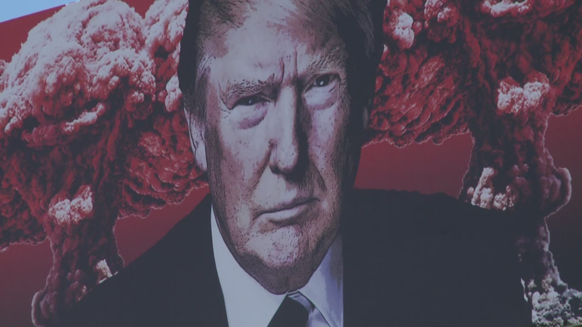 The artist of a billboard that shows the president flanked by mushroom clouds and swastika-like dollar signs has received death threats.