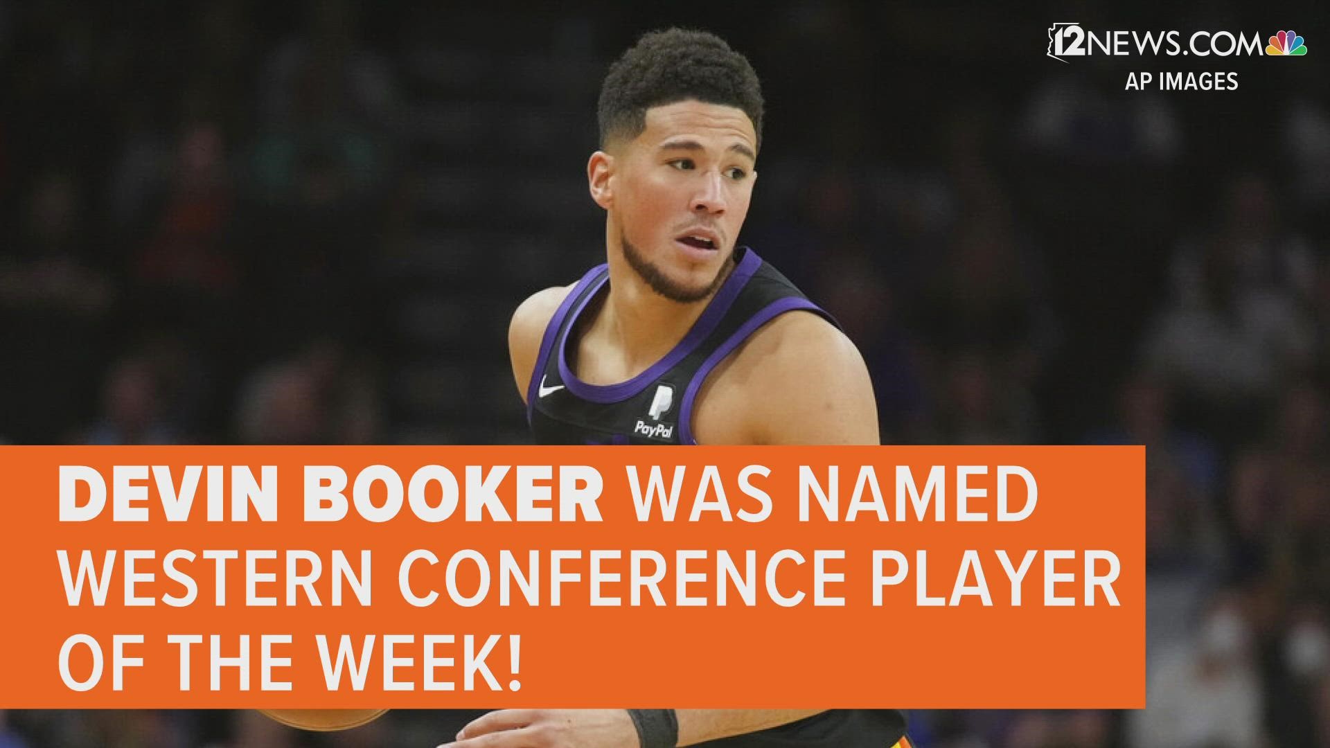 Phoenix Suns guard Devin Booker rubs the Western Conference trophy