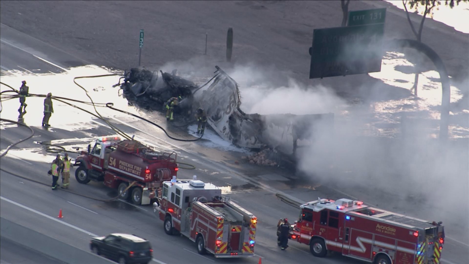 Flames and thick black smoke can be seen coming from a semi.