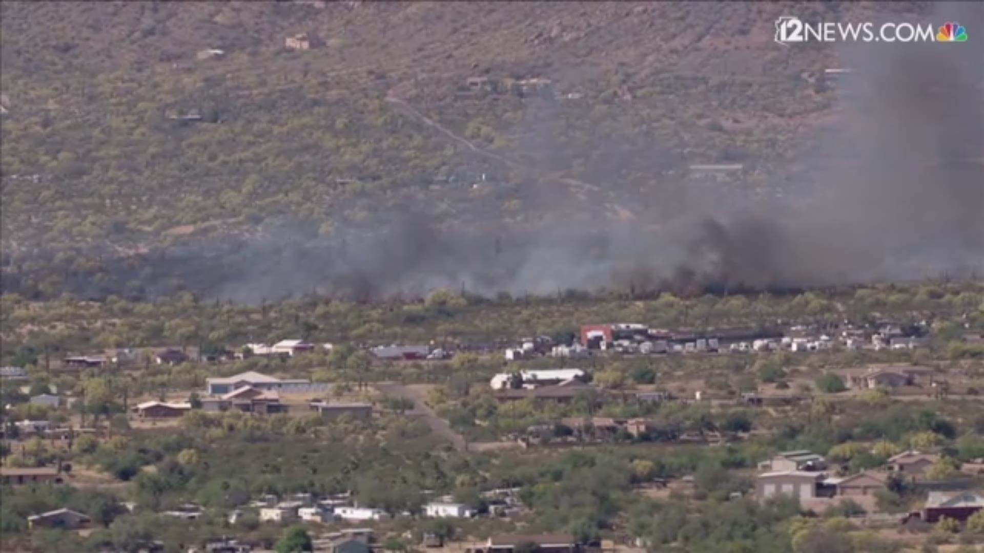 Over 50 firefighters are still working to put out a brush fire that's forced road closures and evacuations in Apache Junction. The fire is near the rodeo grounds.
