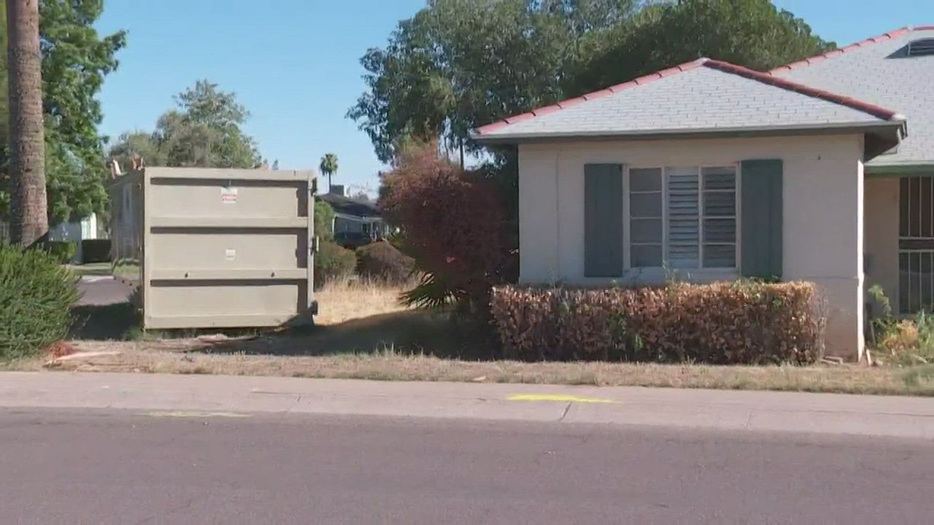An industrial sized dumpster sitting in the front yard of a home on the corner of 17th Avenue and Flower Street.