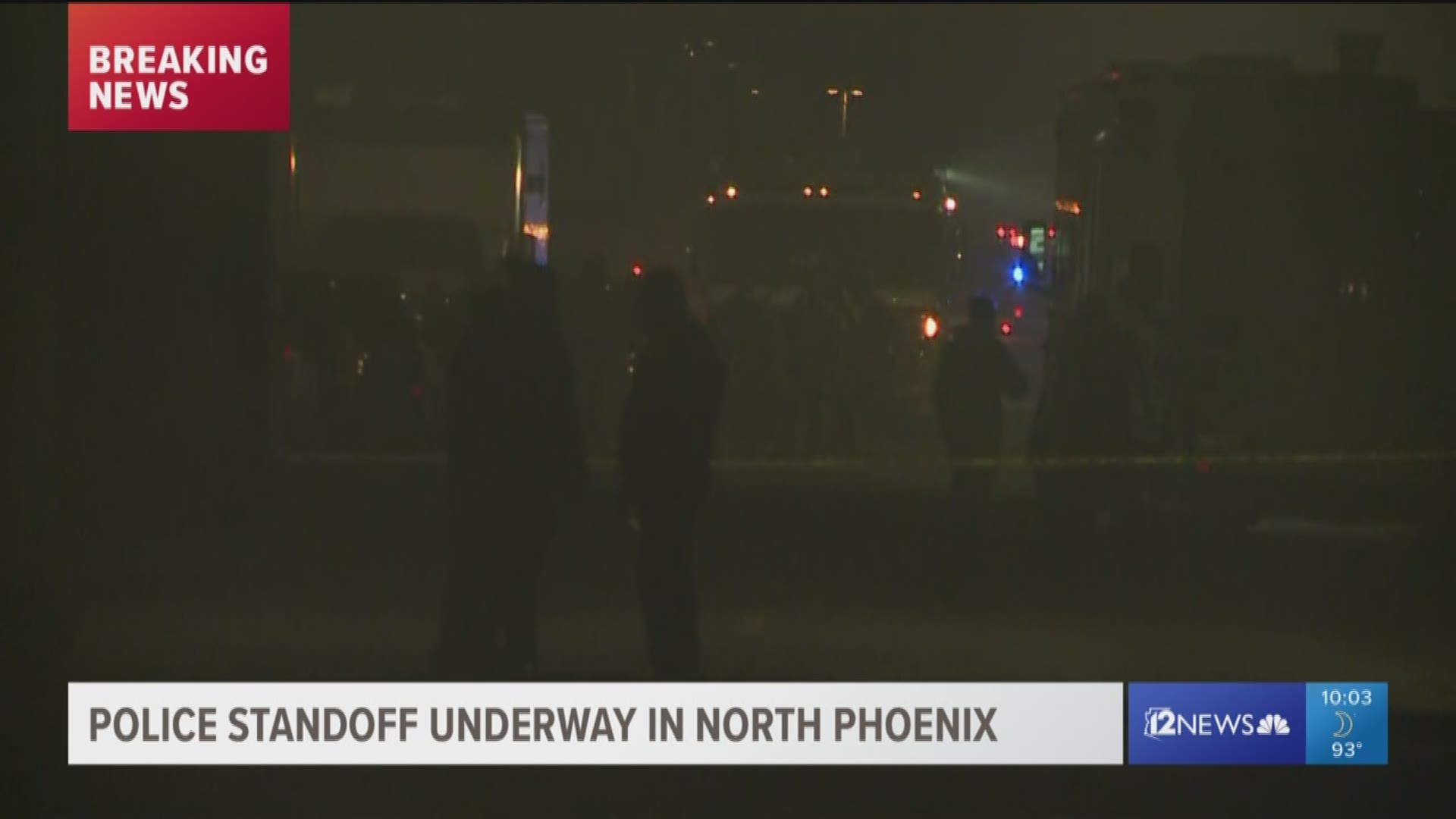 One armed robbery suspect is in custody while another is still barricaded in a north Phoenix home that appears to be on fire.