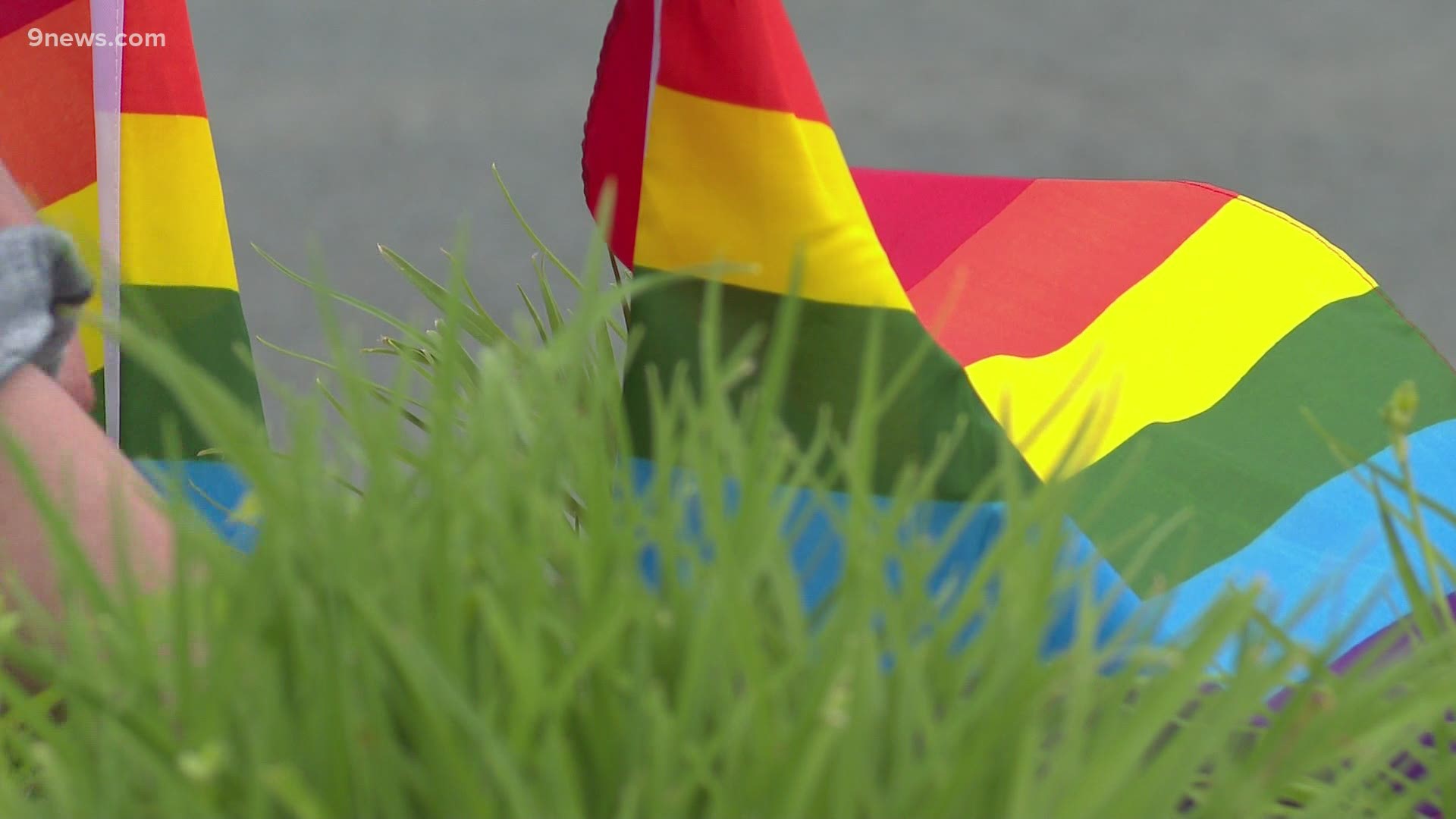 The mayor, a city council person and the executive director for Out Boulder County replace pride flags at McCaslin Boulevard and Centennial Parkway.