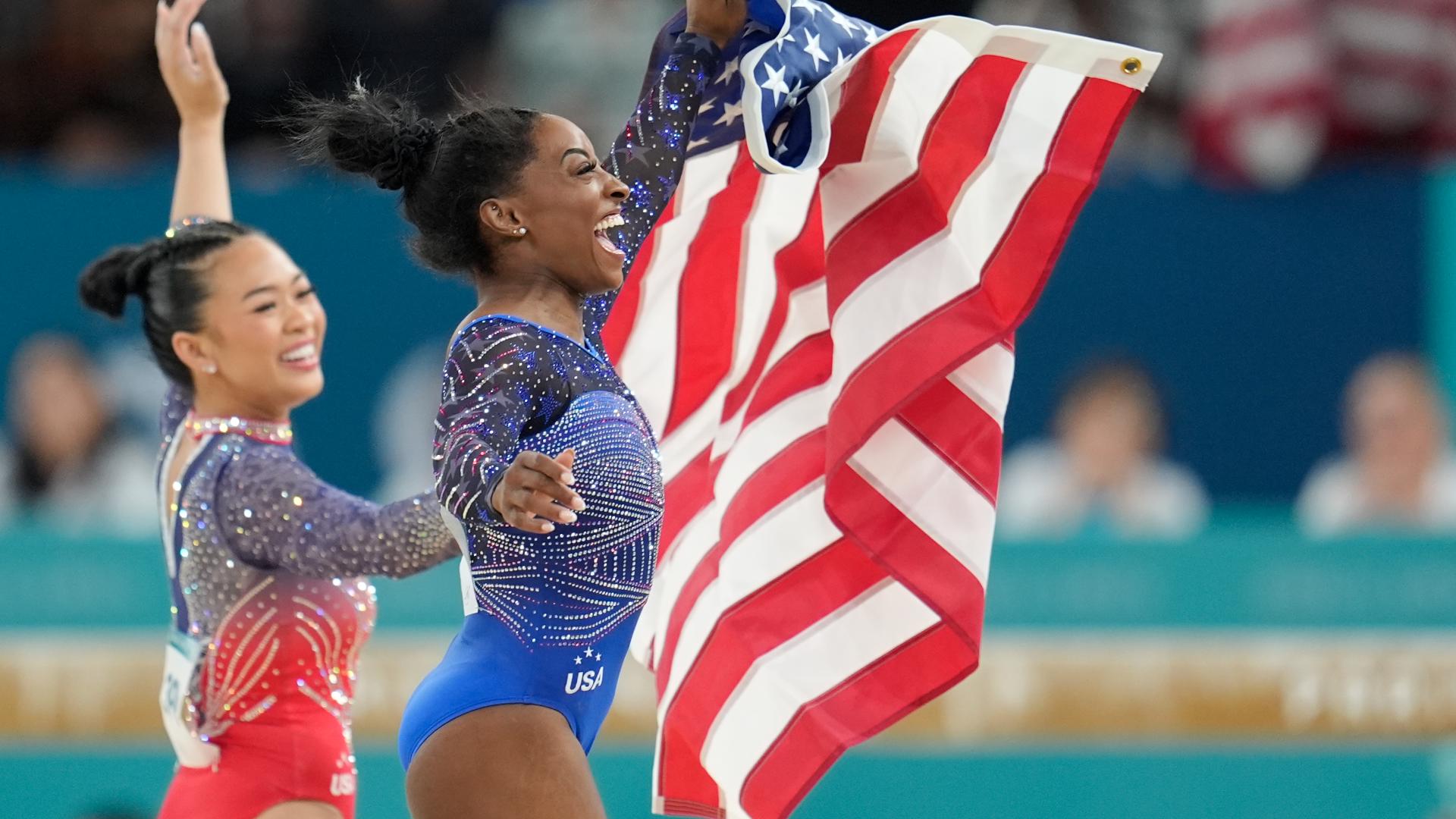 Simone Biles celebrates with teammate Suni Lee, left, after Biles won gold and Lee won bronze in the women's artistic gymnastics all-around finals.