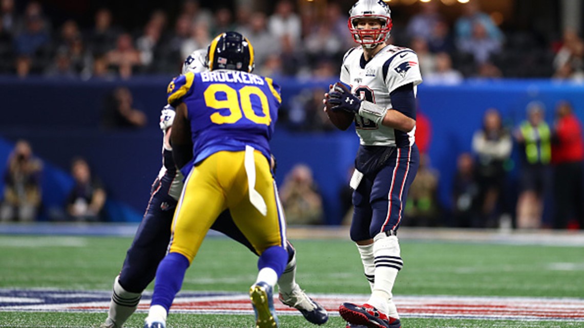 New England Patriots' Tom Brady (12) passes under pressure form Los Angeles  Rams' Aaron Donald (99) during the first half of the NFL Super Bowl 53  football game Sunday, Feb. 3, 2019